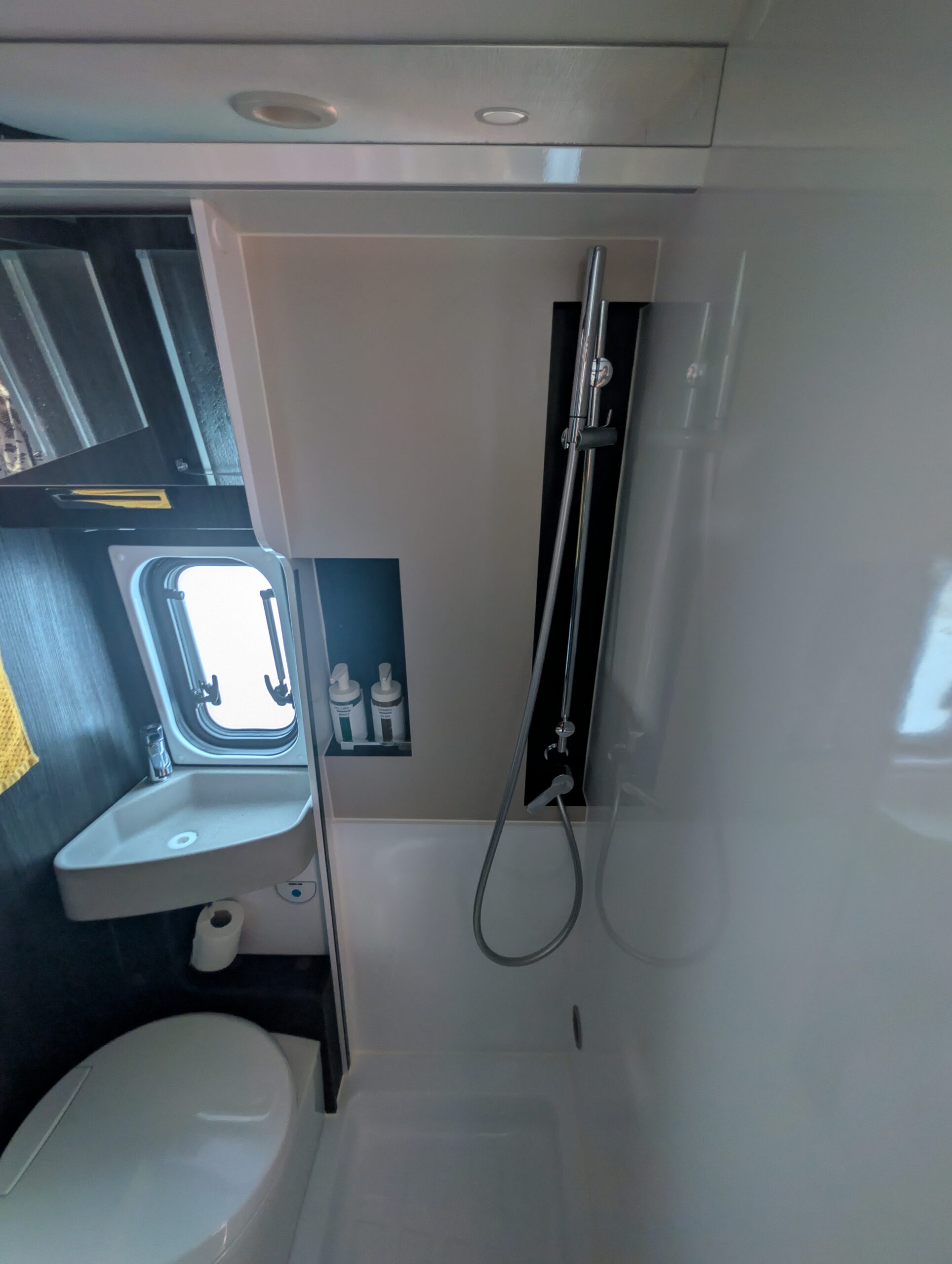 Baño interior completo con WC químico y ducha con mampara rígida en camper